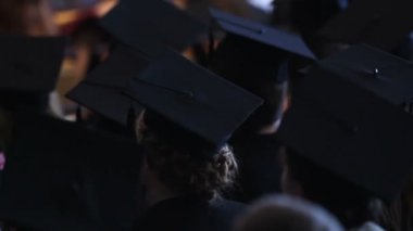 Akademik elbiseler Üniversitesi'nde mezuniyet töreni izlerken genç kadın