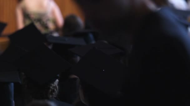 Group of students in academic dress waiting for graduation ceremony in hall — Stock Video