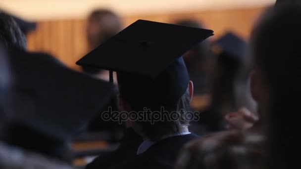 Серйозний випускник спостерігає за церемонією випуску, надією на майбутнє, освітою — стокове відео