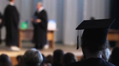 Öğrenci mezuniyet töreni, diploma alacak insanlar sahnede seyir