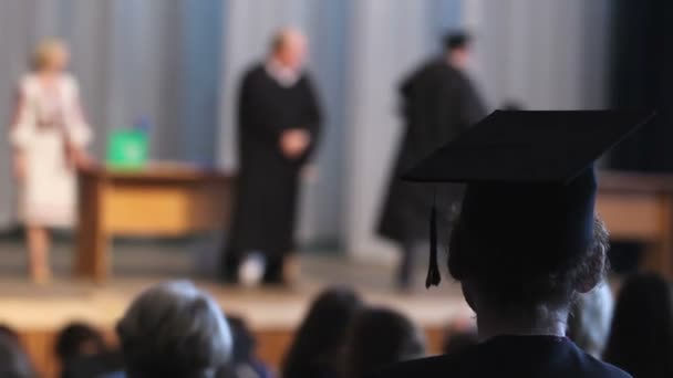 Кудрявый выпускник в выпускной шапке церемония наблюдения, шаг в счастливом будущем — стоковое видео
