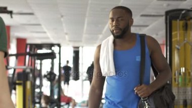 Kendinden emin ve başarılı Afro-Amerikan erkek spor salonunda egzersiz yaptıktan sonra uyuşuk bırakarak.