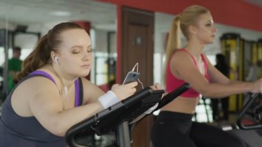 Sabit Bisiklet aktif ince sarışın eğitim bakarak tembel obez kız