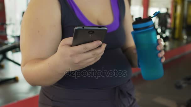 Lady zwaar ademhaling na training, controle van de resultaten op smartphone fitness app — Stockvideo