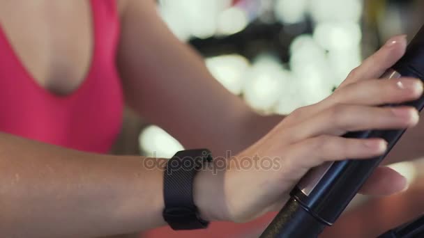 Ragazza snella guardando braccialetto di fitness monitoraggio dei progressi del suo allenamento, palestra — Video Stock