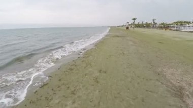 Kıbrıs, düşük sezon, kum üzerinde deniz yosunu bir plaj boyunca güzel hava vurdu