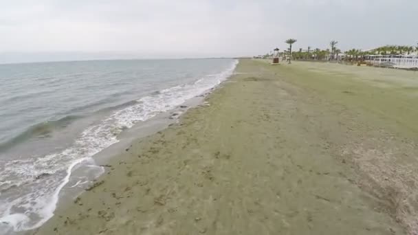 Красивая воздушная съемка вдоль пляжа на Кипре, низкий сезон, морские водоросли на песке — стоковое видео