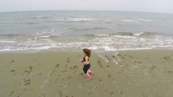 Arial utsikt över kusten, kvinna kör längs stranden, idrott och hälsa — Stockvideo