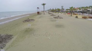 Hava saman şemsiye ve avuç içi, turizm ile kıyı şeridi boyunca vurdu ve rahatla