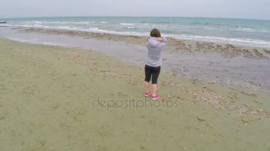 Muhteşem manzarayı denizde sahilde duran kıvırcık saçlı güzel Bayan