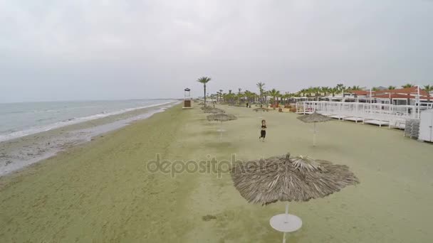 Mujer bonita corriendo en la playa, estilo de vida saludable, tiro aéreo a lo largo de la orilla — Vídeo de stock