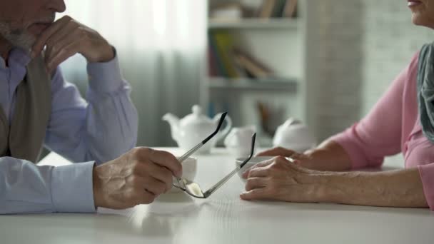 Casal de idosos sentado em frente à mesa sobre xícara de chá, relacionamento tenso, crise — Vídeo de Stock