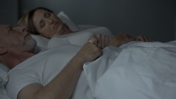 Роздратований літній чоловік дивиться на свою сплячу дружину, шлюб без любові, лють — стокове відео
