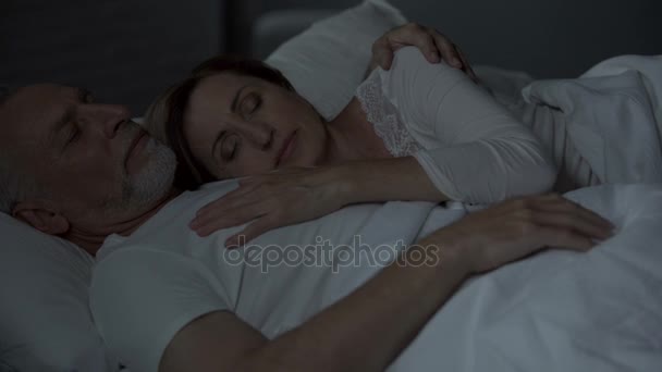 Starší manžel a manželka spí v posteli, Žena dát hlavu na hruď člověka, milující — Stock video