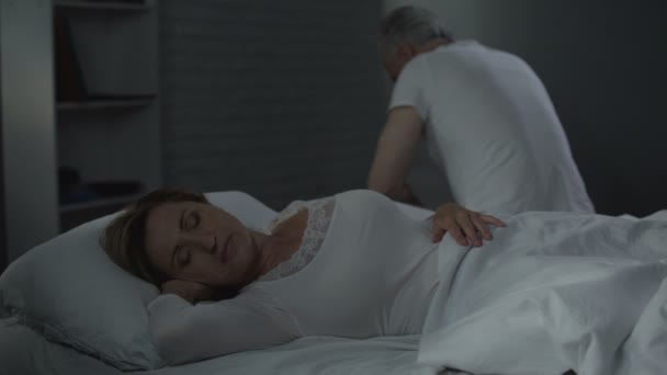 Vezető nő alszik, visszafelé ágy túlsó szélén ülő ember, férfi egészség — Stock videók