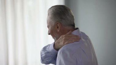 Yana doğru ayakta, akut ağrı boyun dokunmadan, kafa taşımaya çalışıyor yaşlı adam