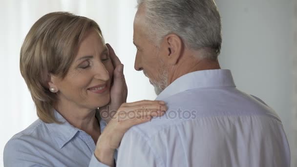 Donna in pensione guardando marito, uomo che si cupa la guancia, felice tarda età adulta — Video Stock