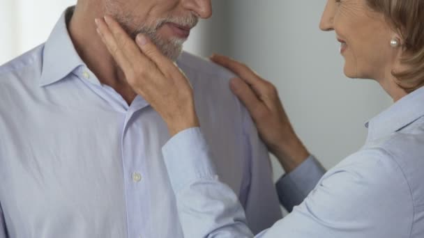 Kvinnlig pensionär koppning manliga kinden, mannen som kysser hennes hand, harmoniskt familjeliv — Stockvideo