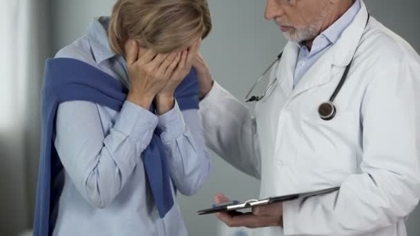 Äldre läkare tröstar gråtande kvinna, upprörande nyheter, terminal stadium av sjukdomen — Stockvideo
