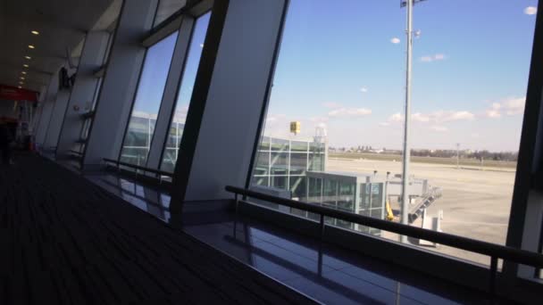 Современный аэропорт, прекрасный вид на взлетно-посадочную полосу и пассажирский терминал через окно — стоковое видео