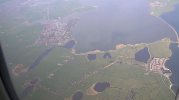 Flugzeugfensteraufnahme, atemberaubender Blick auf Meer und Stadt aus dem Flugzeug, Flugreise — Stockvideo