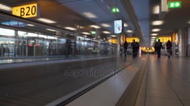 Kadınlar ve erkekler Havaalanı terminal, altındaki yürüyen merdiven üzerinde taşıma çantaları ile göster