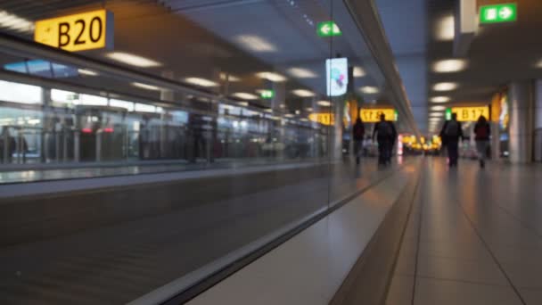 Donne e uomini con borse che si muovono sulla scala mobile al terminal dell'aeroporto, vista dal basso — Video Stock