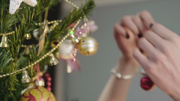 Las manos femeninas colgando cuidadosamente juguete muñeco de nieve festivo en el hermoso árbol de Navidad — Vídeos de Stock