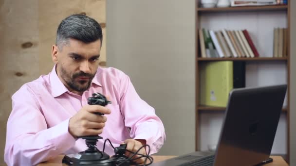 Male employee killing time, playing video game simulator instead of working — Stock Video