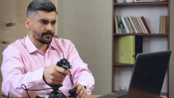 Hombre adulto perdiendo el tiempo en el trabajo, jugando shooter videojuegos con joystick — Vídeos de Stock