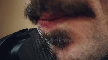 Dikkatle sakalını Elektrikli tıraş makinesi ile aşırı closeup damat erkek