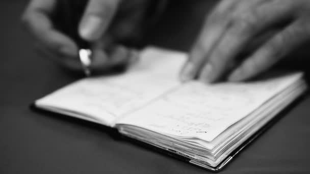 Periodista tomando notas en su cuaderno de bolsillo después de aprender información — Vídeo de stock
