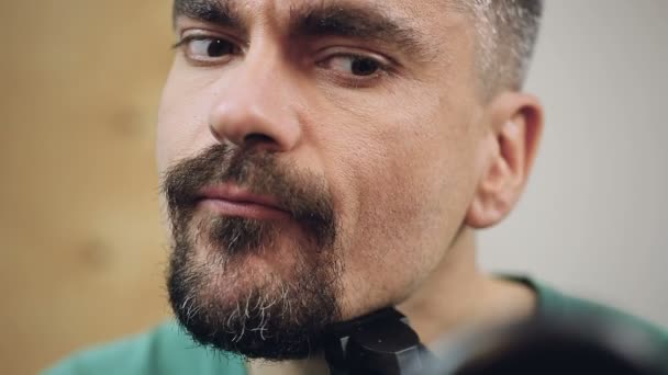 Hombre guapo con atención arreglando su barba, preparándose para ir a una primera cita — Vídeos de Stock