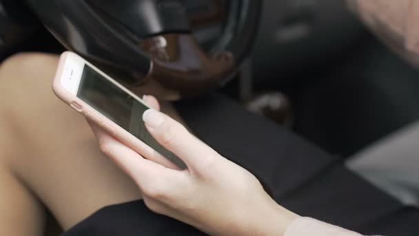 Ділова жінка прокручує соціальні медіа, сидячи в машині з гаджетом в руках — стокове відео