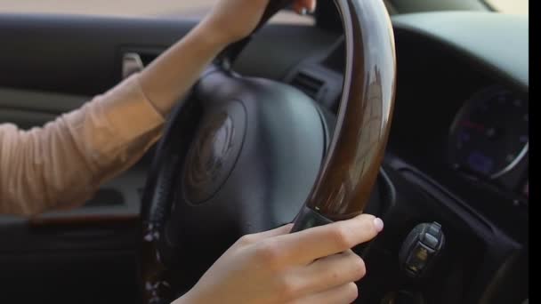 Jeunes mains féminines tenant avec confiance le volant de la voiture, femme conduisant — Video