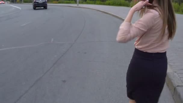 Slim jeune femme marchant le long de la route en essayant d'attraper tour au service de voiture le plus proche — Video