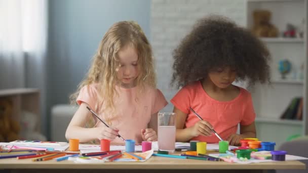 Garotas caucasianas e afro-americanas atentas pintando na escola de arte, tempo de lazer — Vídeo de Stock