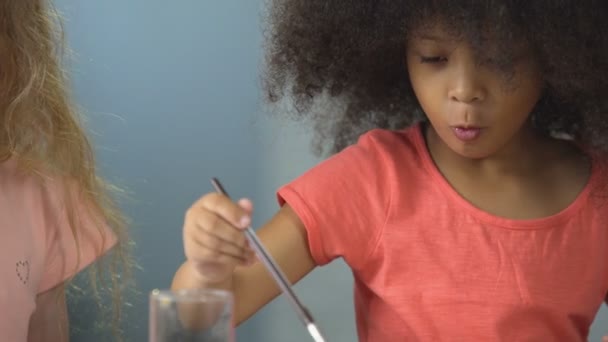 Lockige afrikanisch-amerikanische Mädchen malen mit Aquarellen im Kindergarten, Hobby — Stockvideo