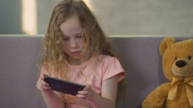 Güzel bir kadın çocuk oyun smartphone, gadget bağımlılığı, çocukluk keyfi