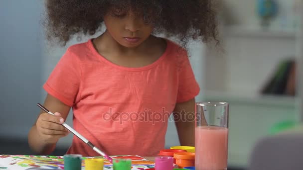 Pintura chica de pelo negro rizado con acuarelas en la escuela de arte, hobby arte — Vídeo de stock