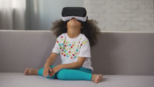 Afro-amerykański dziewczyna sobie zestaw wirtualnej rzeczywistości i gry, reszta — Wideo stockowe