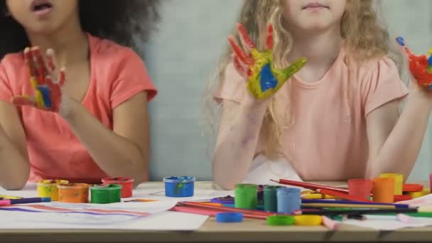Divertidos niños afroamericanos y caucásicos con palmas pintadas divirtiéndose en el taller — Vídeo de stock