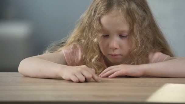 Menina de cabelos longos ressentido sentado à mesa e pensando sobre o próprio comportamento — Vídeo de Stock