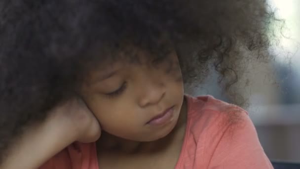 テーブルに座って、お母さんについて考えて孤独のアフリカ系アメリカ人の女性の子供 — ストック動画