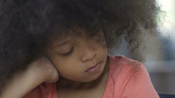 Lonely African American female kid sitting at the table and thinking about mom — Stock Video