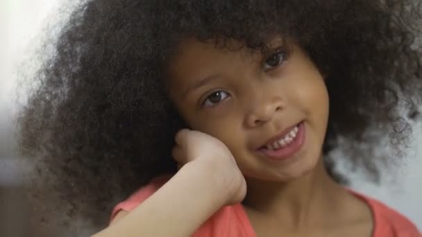 Lindo niño afroamericano posando para la cámara y sonriendo, primer plano, felicidad — Vídeos de Stock