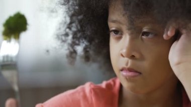 Güzel bir Afro-Amerikan çocuk çatal brokoli parça, organik gıda ile seyir