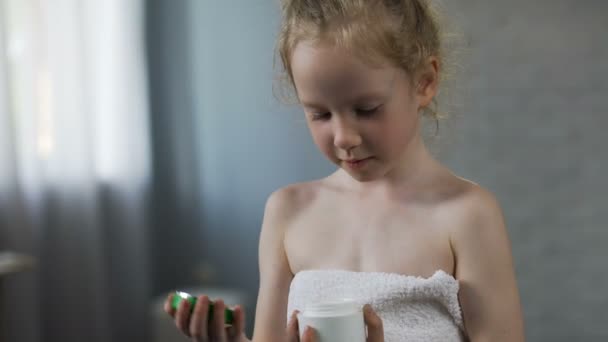 Bonita niña abriendo el tubo de crema y preparándose para los procedimientos diarios de belleza — Vídeos de Stock