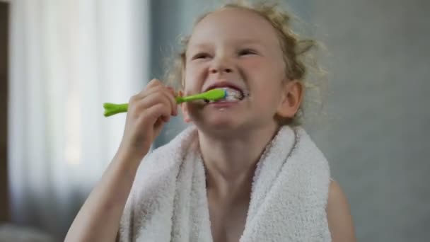 Little girl ijverig haar tanden poetsen, mondhygiëne, ochtendritueel — Stockvideo