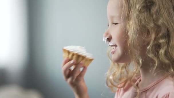 Lustiges blondes Kind, das cremigen Kuchen isst und lächelt, Geburtstagsfeier, Schokoriegel — Stockvideo